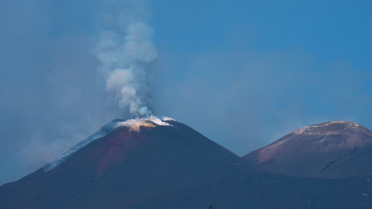 Active volcano Mt. Etna in Sicily, Italy releases steam and erupts lava into the sky