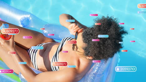 animation of social media notifications over biracial woman sunbathing in pool