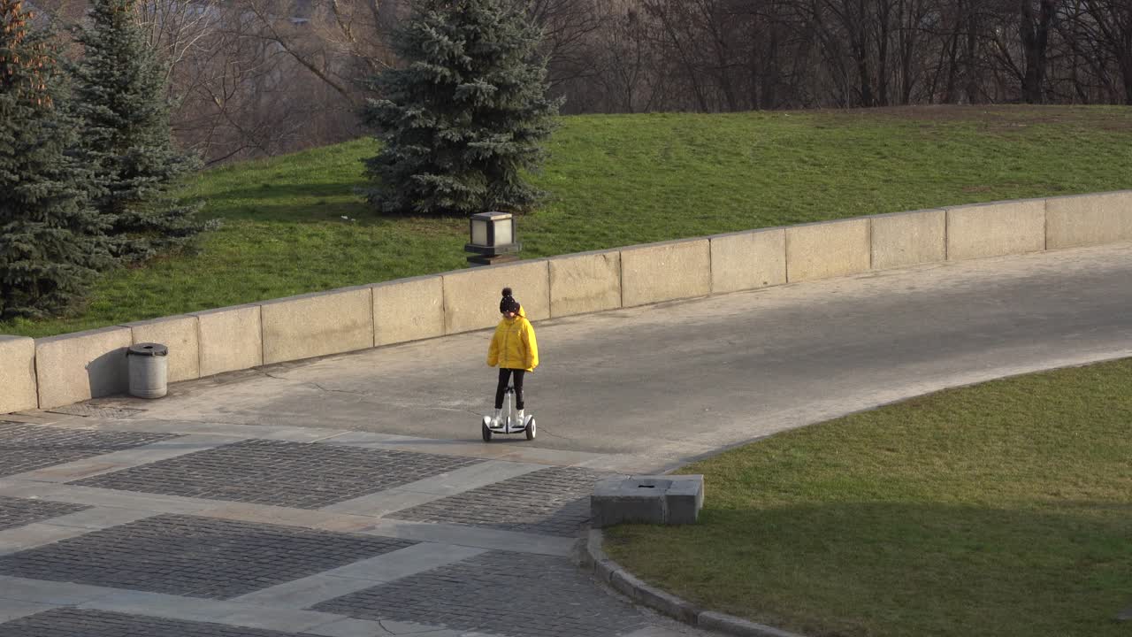 전기 스쿠터를 타는 작은 소녀 . 개인 에코 운송, 자이로 스쿠터, 스마트  ⁇ 런스  ⁇ . 인기 있는 전기 운송