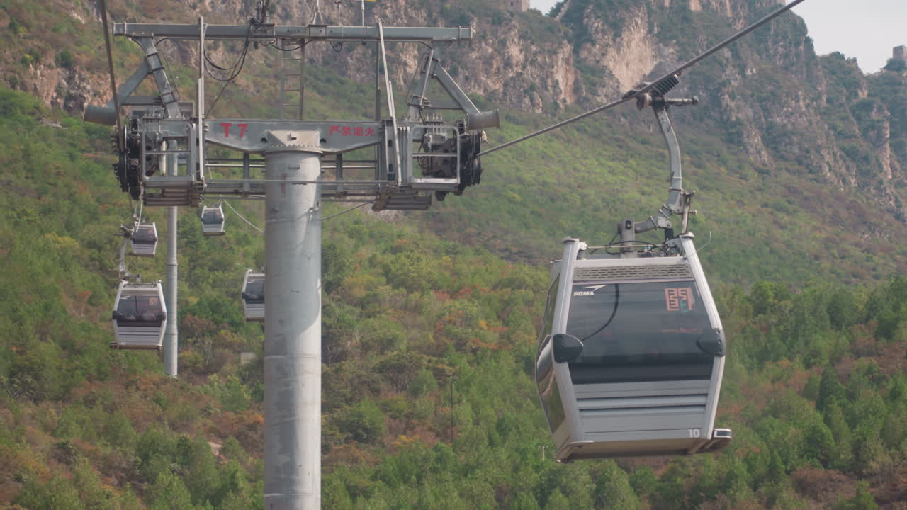 Cabine della gondola scivolano su una montagna boscosa, i turisti si godono un giro panoramico, un fotografo inquadra creste distanti, un ingegnere ispeziona un pilone, un ranger osserva da un punto panoramico, atmosfera calma e coinvolgente