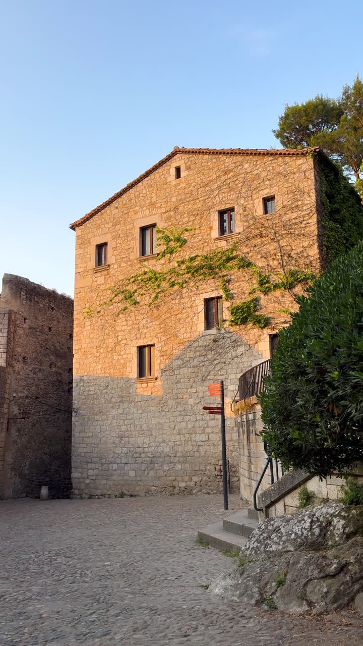 Warm sunset over ancient Girona building evokes history and tranquility