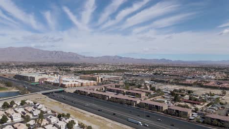 slow aerial forward of traffic on highway in summerlin cityscape, suburb of las vegas during beautiful sunny day