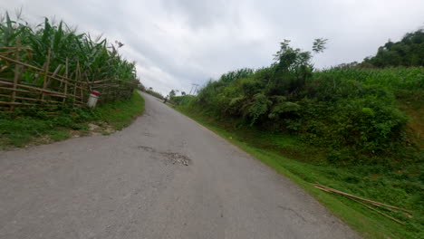 pov scooter journey through ha giang loop, winding mountain roads and scenic vistas along grassy hills and farmland