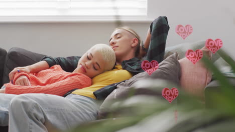 animation of hearts with love you texts over diverse female couple sleeping at home