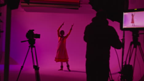 film or video studio recording female kathak dancer wearing traditional indian dress preparing for performance