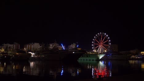Ferris-wheel-next-to-yachts-in-Barcelona-at-night