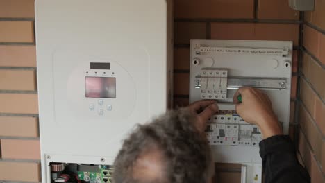 an electrician installing an inverter in a home. the image shows technical skill, modern tools, and attention to safety in electrical work