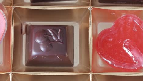 heart-shaped lollipop being poured into chocolate molds for valentine's day treats