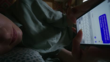 woman texting on smartphone in bed at night