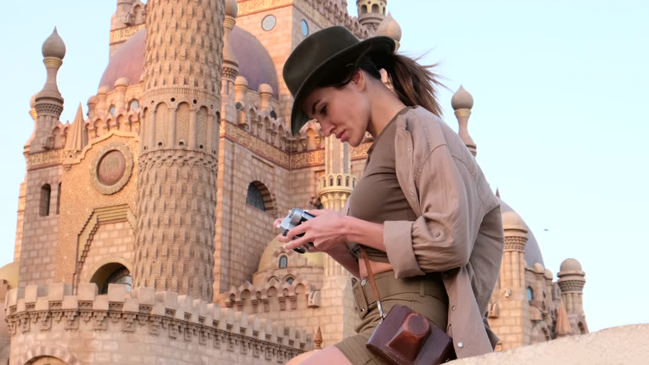 un turista se para con una cámara cerca de la mezquita, minaret.arqueología