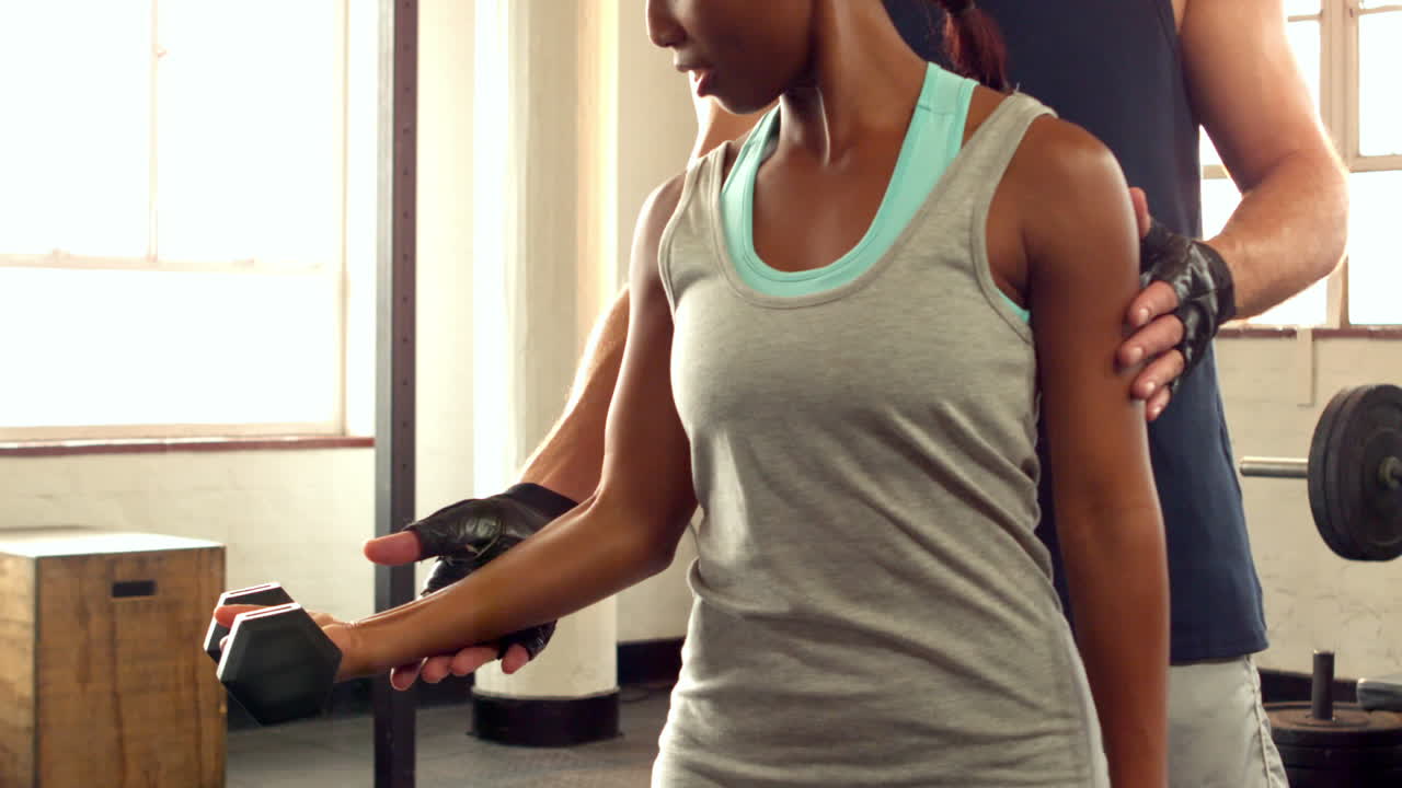 entrenador ayudando al cliente a levantar pesas