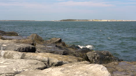 the ocean waves breaking in the rock jetty