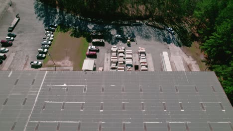 overview aerial hotshot truck with flatbed trailer, forklift driver loading with cement sidings