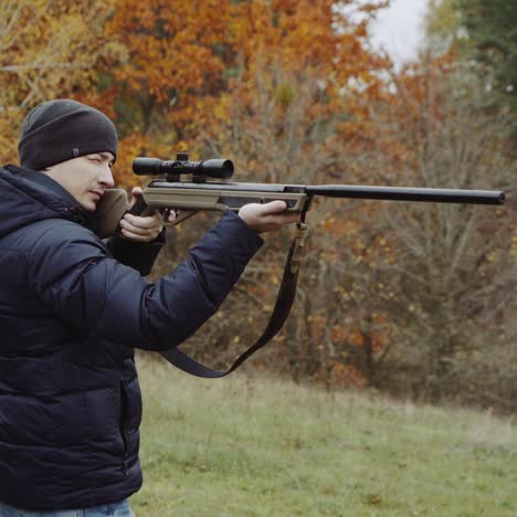 hombre disparando un arma en el bosque