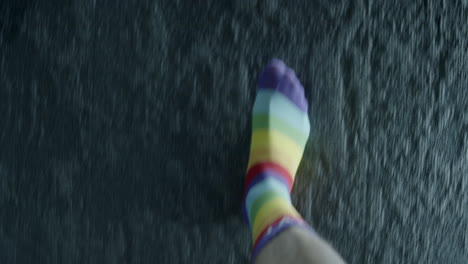 person walking with rainbow striped socks