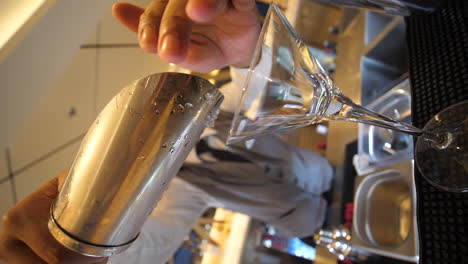 él está agregando cubitos de hielo en el vaso
