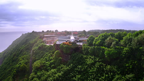 Private-jet-plane-perched-on-coastal-cliff-with-lush-foliage-in-Bali