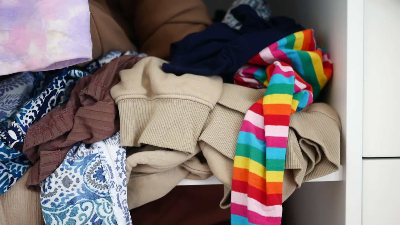 un estante desordenado con ropa plegada