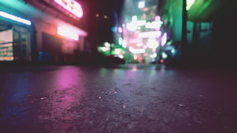 una vista borrosa de una calle de la ciudad por la noche con luces de neón