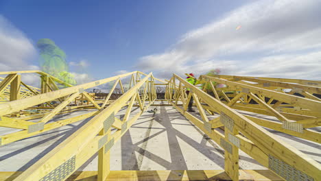 workers constructing roof trusses on sunny and cloudy day