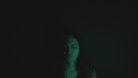 young man with eyes closed in dark studio and light projected on face