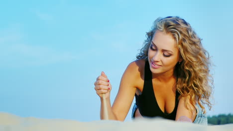 Attractive-Young-Woman-Resting-On-The-Beach-Playing-Lies-Against-The-Sky