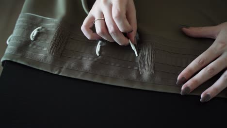 woman finishing self sewed curtains at home, close up view