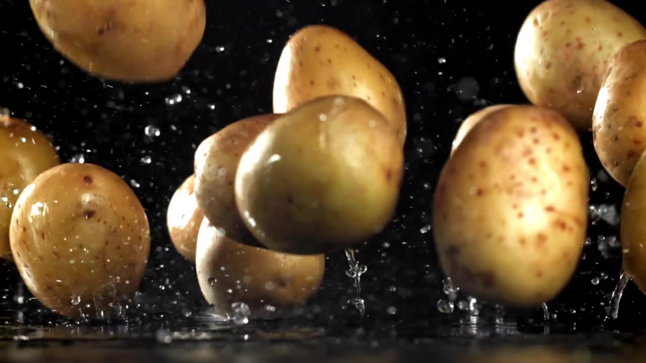 Patate fresche che cadono nell'acqua con schizzi al rallentatore