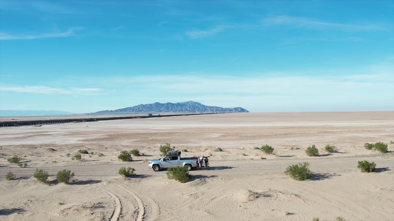 Driving along a sandy road on the Baja Peninsula with a backdrop of the sole hill in the distance