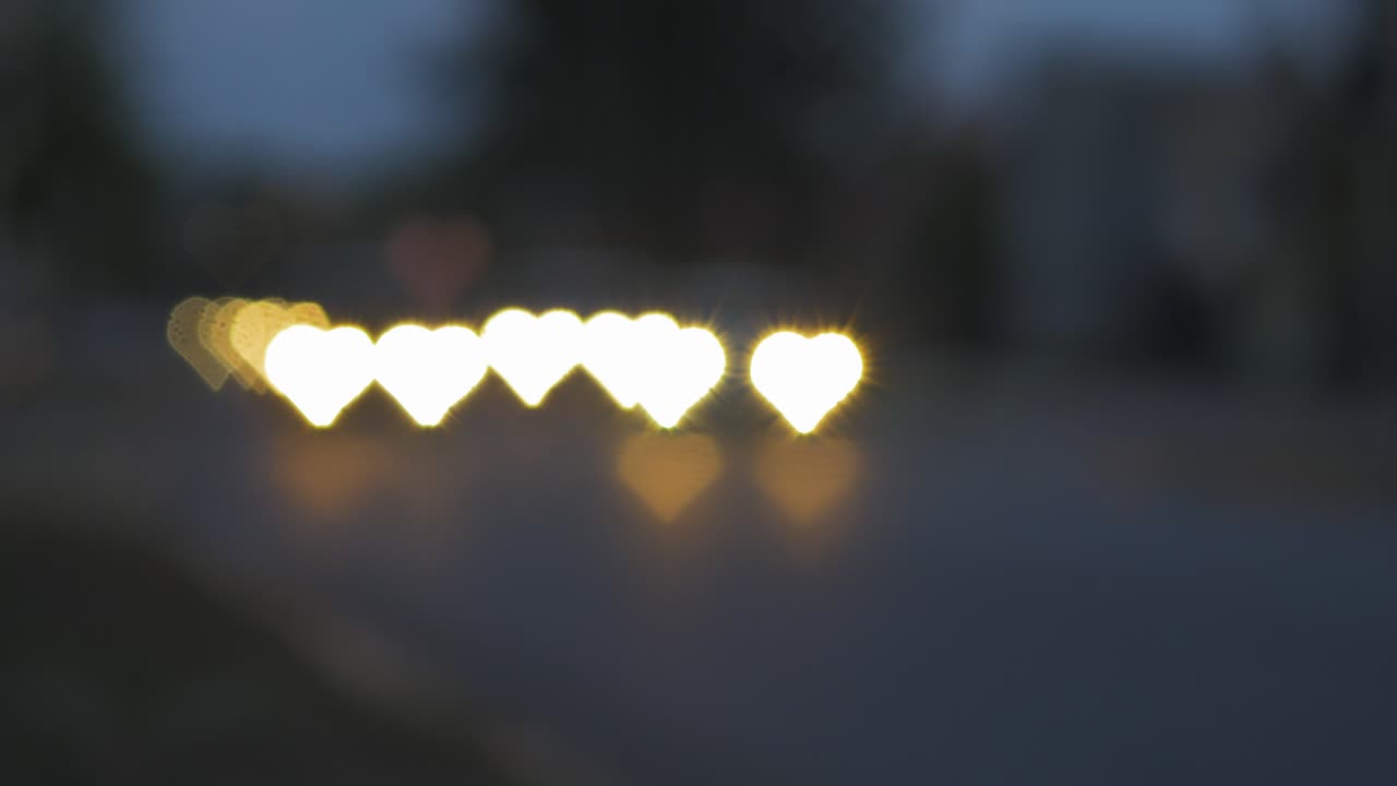 bokeh de hermosos corazones del coche en movimiento y semáforos en la noche, el día de san valentín o las redes sociales como concepto de fondo