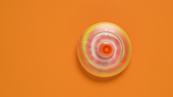 Kids whirligig humming spinner on orange background