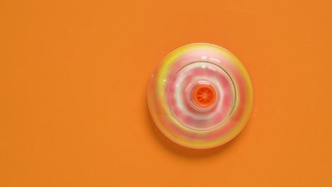 niños girando zumbando girador en fondo naranja
