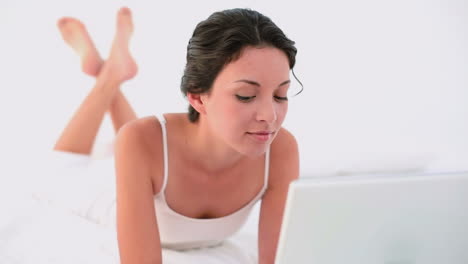 una morena pensativa usando su portátil