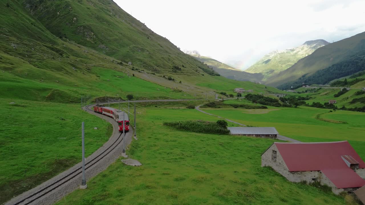 Train going through the scenic Swiss Alps during summer at Furka Pass, shot from a drone in 4K