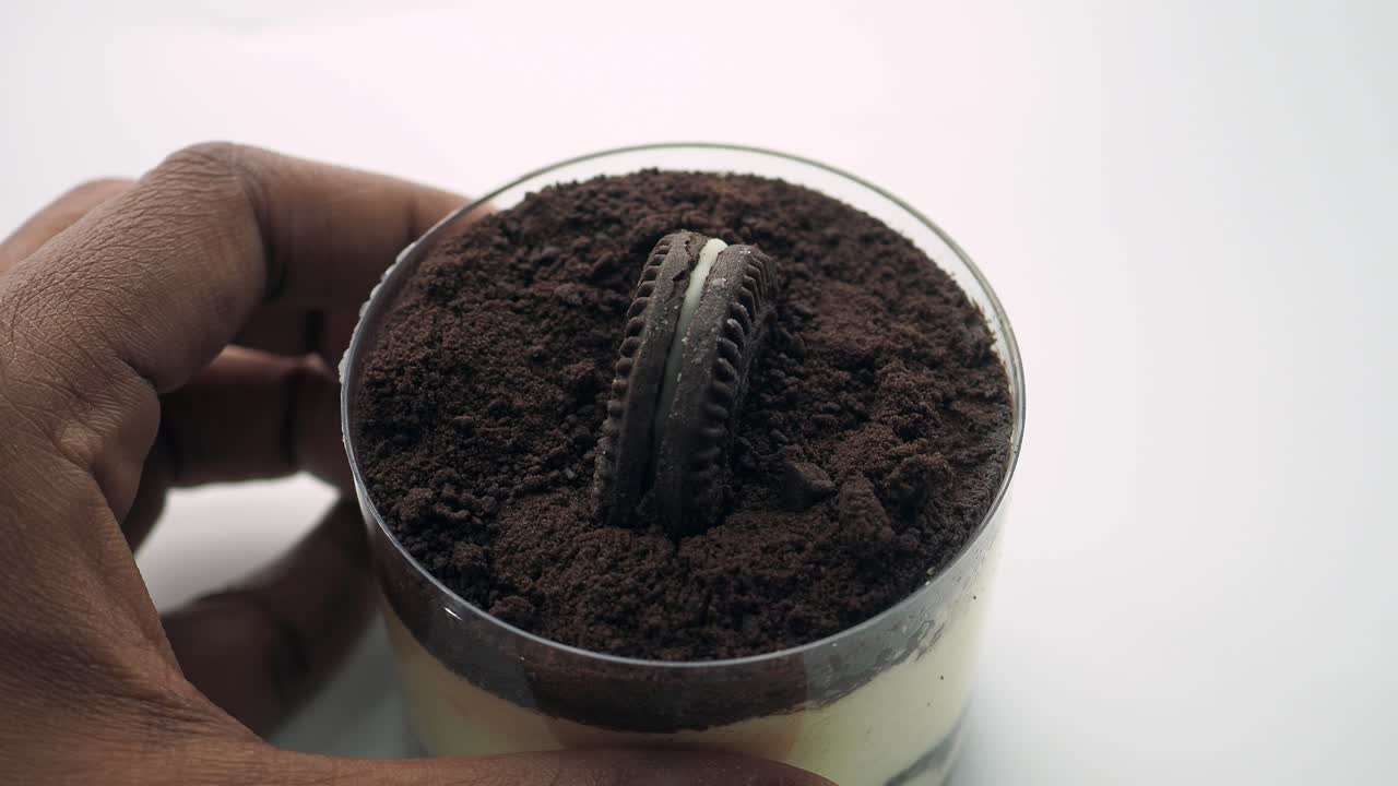 초콜릿 쿠키와 함께 손에 들고 있는 티라미수 디저트