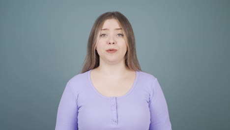 young woman looking at camera in amazement.