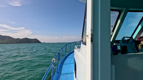 a boat glides through phuket's turquoise waters, offering stunning views of distant islands under clear skies