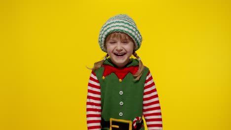 Kid-girl-in-Christmas-elf-Santa-helper-costume-laughing-fooling-around.-New-Year-holiday-celebration