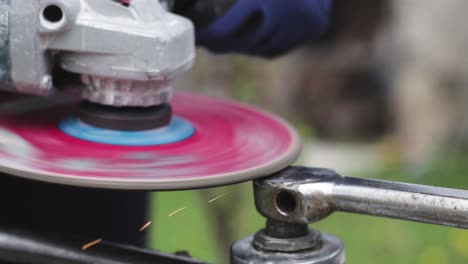 industrial worker grinding metal with a power tool. metal grinding machine