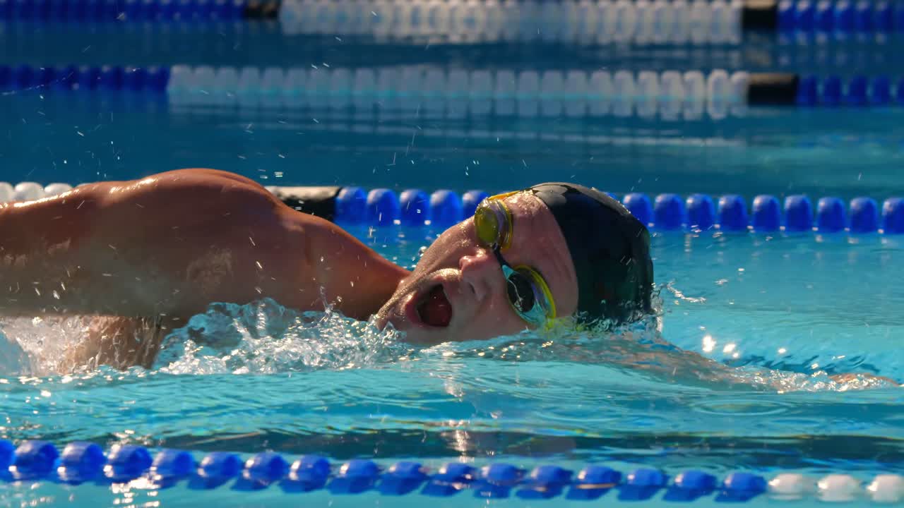 수영장 4k 내에서 수영하는 젊은 남성 수영 선수