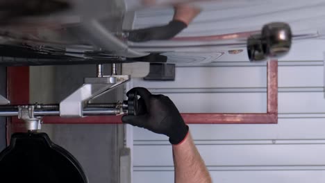 close-up of a gloved hand performing vehicle maintenance