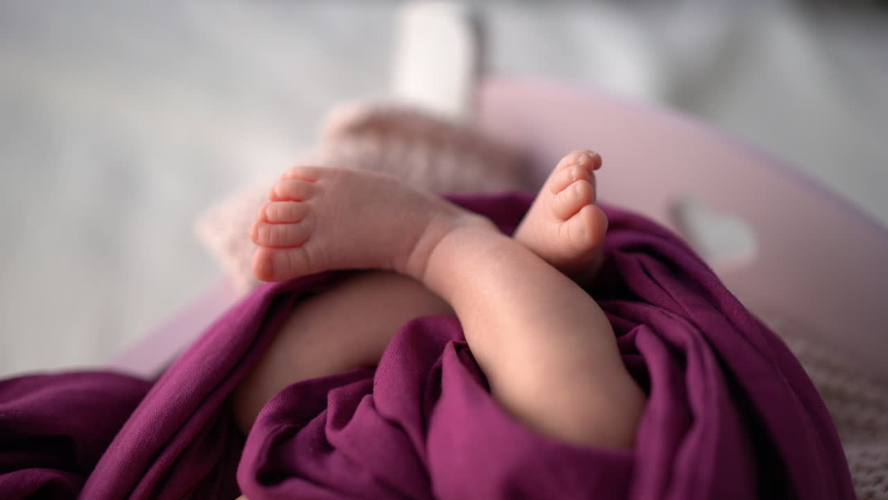 Primo piano di piedini avvolti in tessuto viola