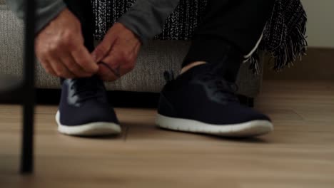 hombre apretando los cordones de sus zapatos deportivos