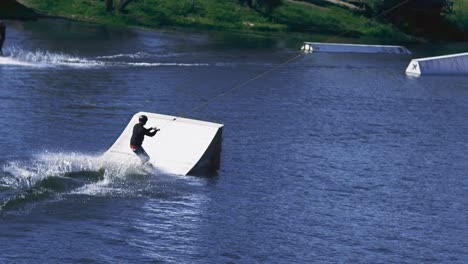 extreme sportsman training tricks on water with springboard