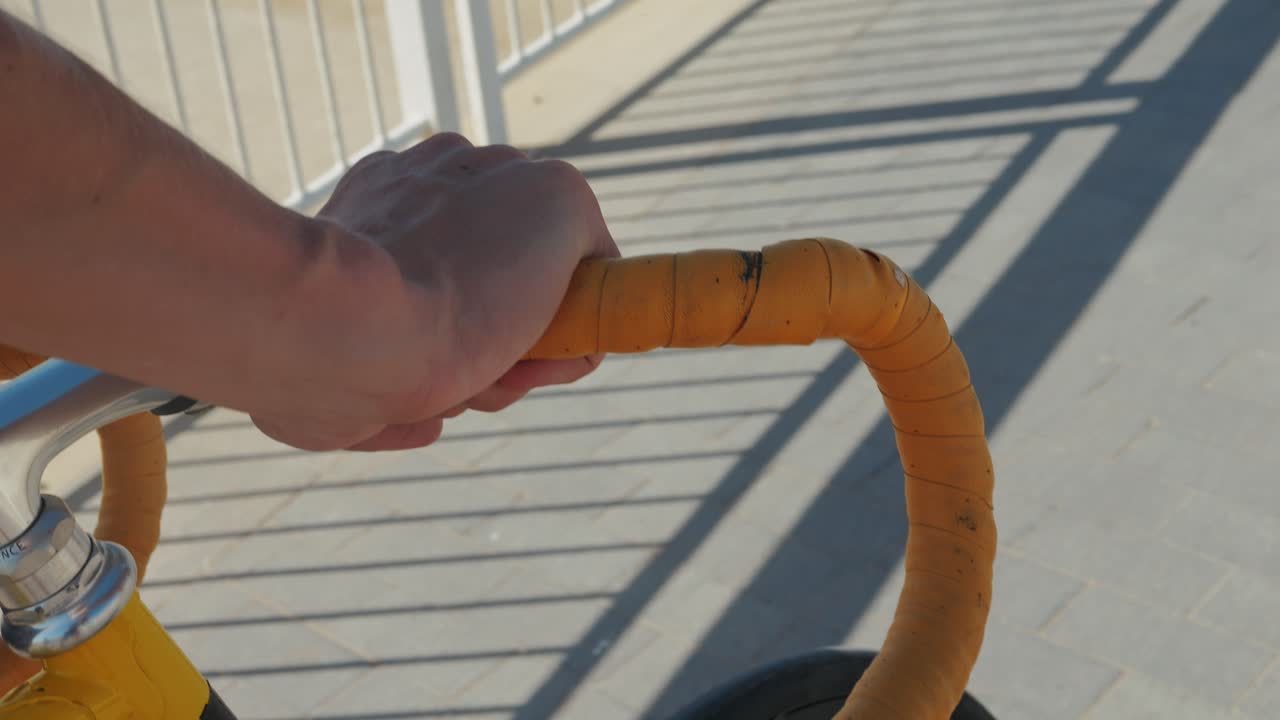 Person Riding a Bicycle on a Bridge with Beach View