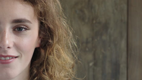 close up portrait of beautiful red head woman smiling friendly looking at camera pretty caucasian female on wooden background half face