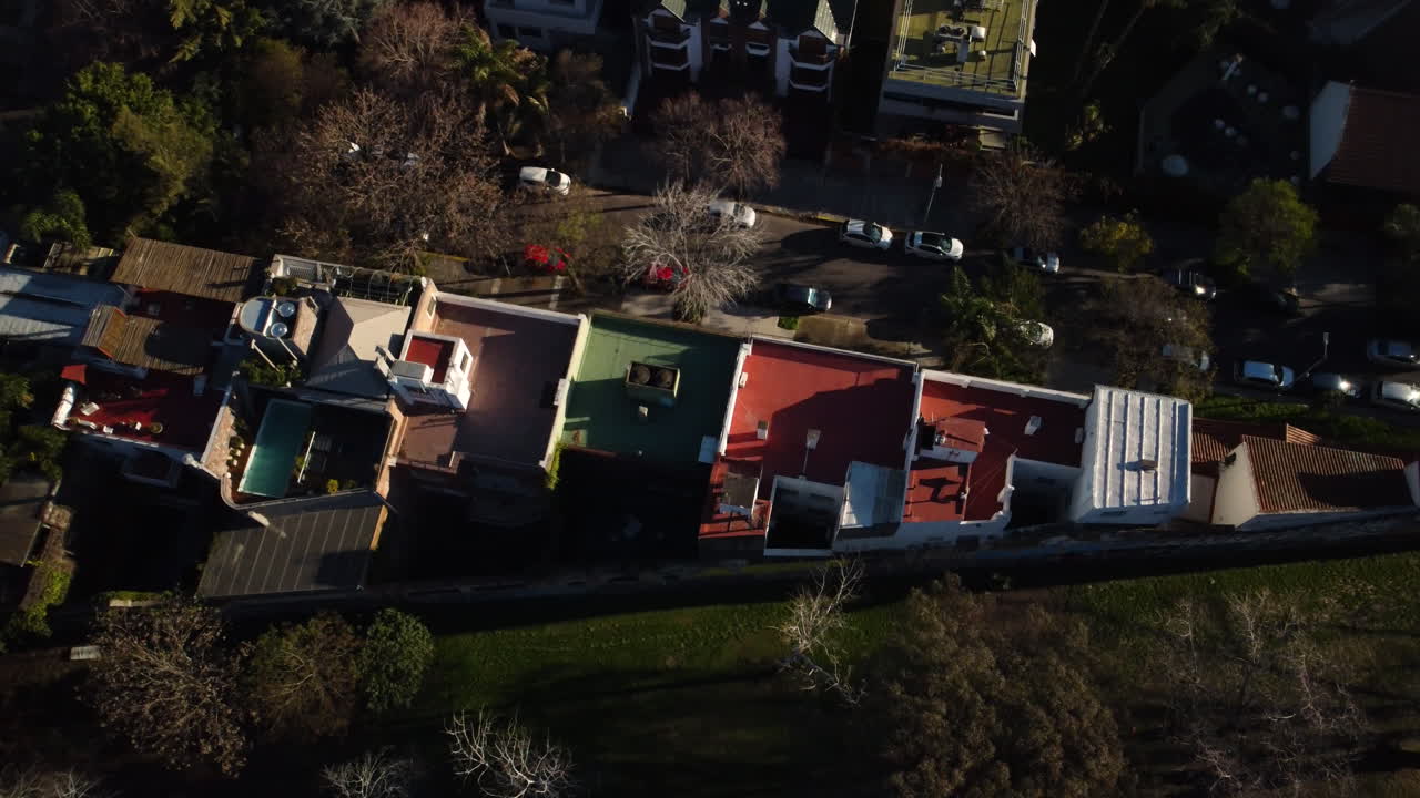 다른 색의 집의 지붕, 집 근처의 도로를 따라 운전하는 자동차, 주거 지역과 공원