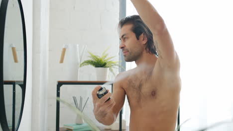 man applying deodorant in bathroom