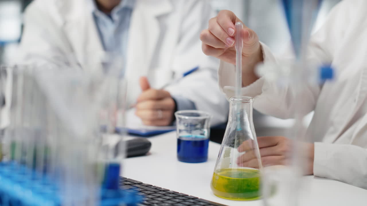 Vertical video Lab manager and trainee shaking glassware filled with green indicator solution