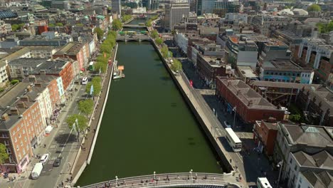 wide, front-on reversing aerial video of the river liffey, various bridges and dublin city centre in dublin, ireland on a bright and sunny day. filmed in 4k, 60fps and with rec709 color.